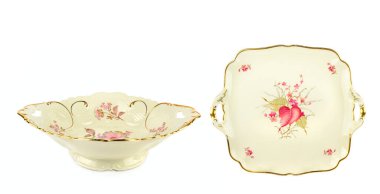 Zarif bir fildişi porselen kase ve pembe çiçek desenleri ve altın jantlarla süslenmiş eşleştirme tepsisi. Fotokopi alanı olan bu izole stüdyo resmi antika dekor ve temalar için idealdir..