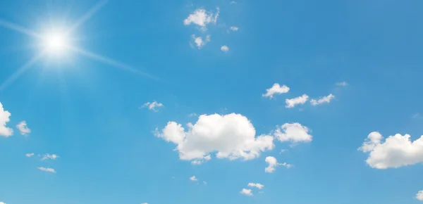 Sun on blue sky with white clouds — Stock Photo, Image