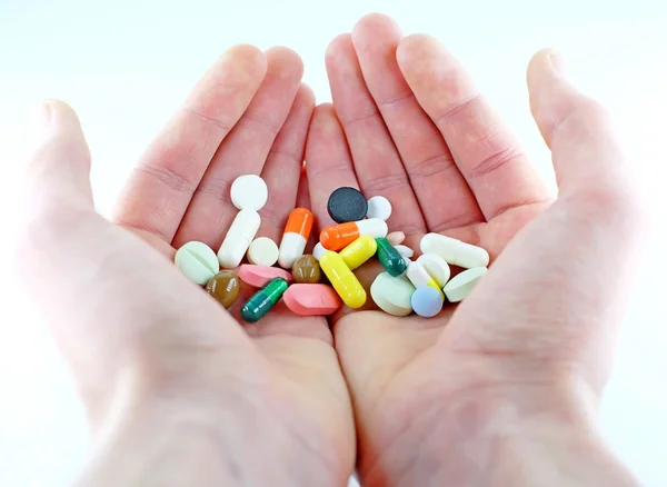 Een verscheidenheid van tabletten in de handen — Stockfoto
