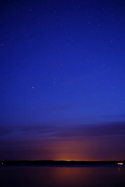 Puesta de sol sobre el lago y el cielo estrellado — Foto de Stock