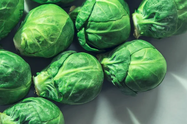 Mermer bir mutfak masasında yeşil lahanaları olan Brüksel lahanası, yakın çekim, makro fotoğraf.