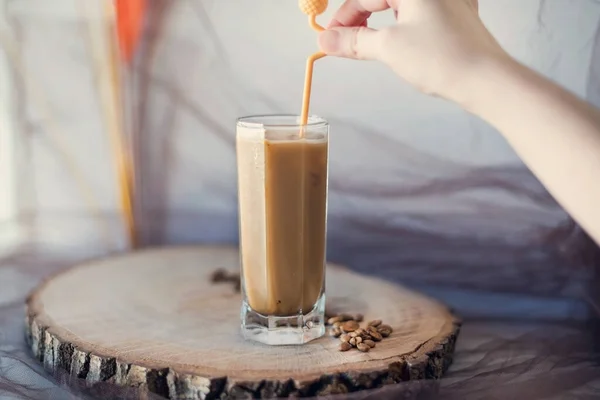 Žena Potřese Studeným Latté Sklem Žlutou Lžičkou Koktejlu Dřevěné Služební — Stock fotografie