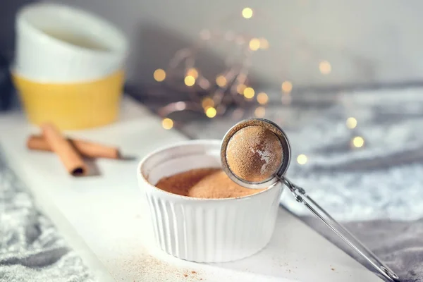Beyaz arka planda tarçın çubukları olan ev yapımı puding.