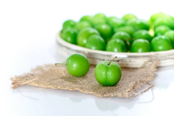 Zwei Grüne Pflaumen Auf Hessischer Textur Mit Einem Teller Pflaumen — Stockfoto