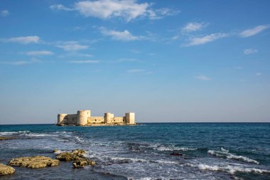 Mersin 'in Mersin ilinde mavi gökyüzü ve kayalık deniz kıyısına sahip ünlü Bakire Kalesi, 11.03.2018