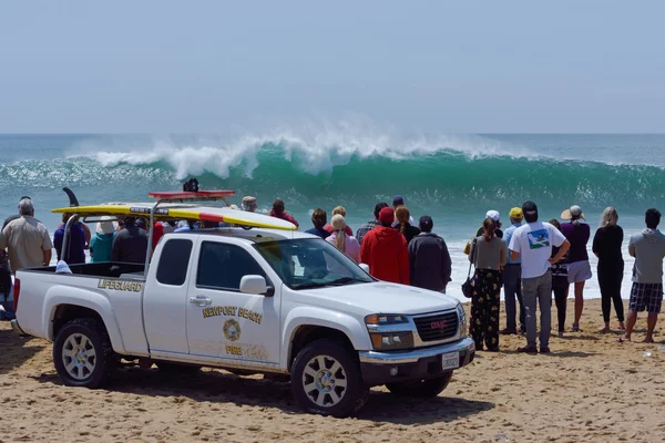 Spectators and lifeguards observing huge surf