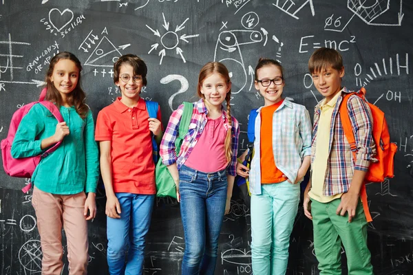 Glückliche Schüler in bunten Kleidern — Stockfoto