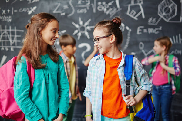 Adorable schoolmates with backpacks