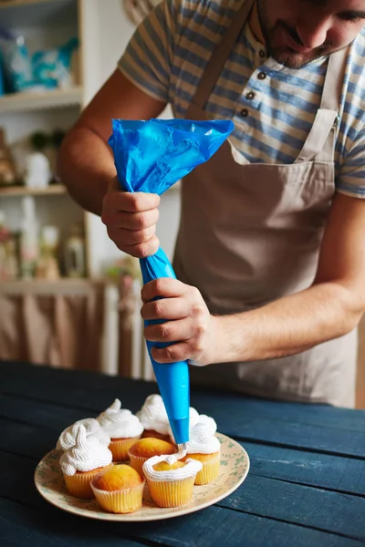 Muž zdobení muffiny — Stock fotografie