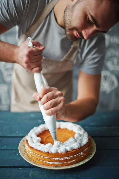 Bäcker dekoriert leckeren Kuchen — Stockfoto