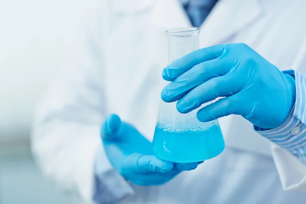 Wissenschaftler mit blauer Flüssigkeit — Stockfoto