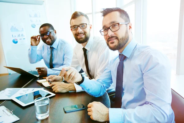 Hombres de negocios sonrientes durante la reunión —  Fotos de Stock