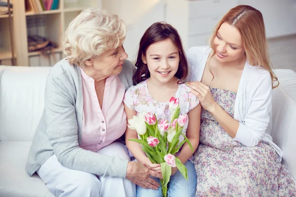 Meisje met familie en bloemen — Stockfoto