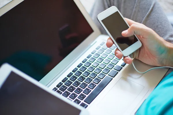 Man with cellphone over laptop — Stock Photo, Image