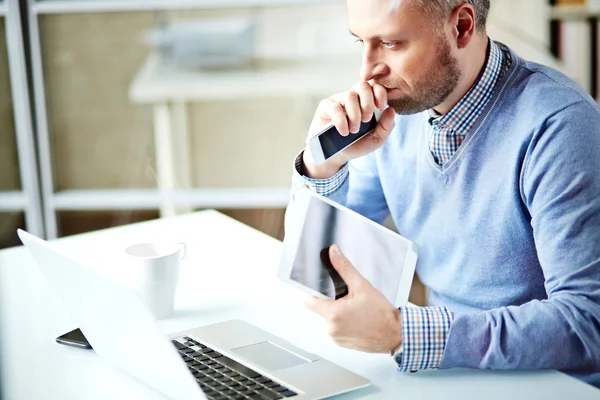 Homem de negócios com touchpad e celular — Fotografia de Stock