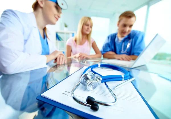 Clipboard and stethoscope with people — Stock Photo, Image