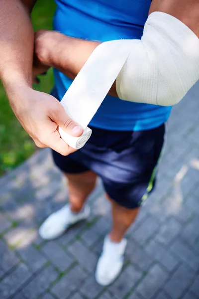 Esportista bandagem cotovelo articulação — Fotografia de Stock
