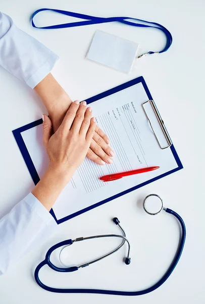 Mãos sobre cartão médico — Fotografia de Stock