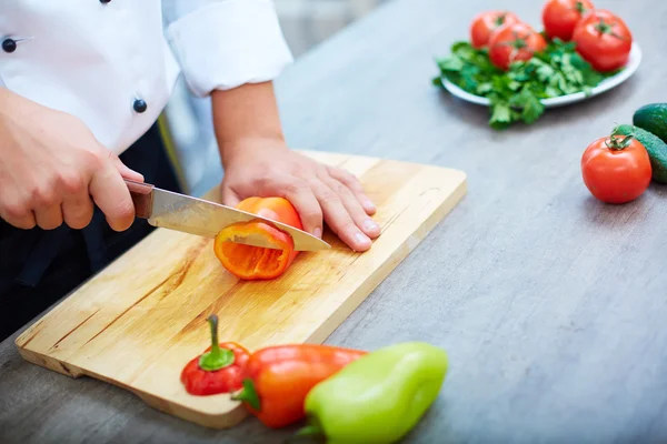 Händer skära peppar — Stockfoto