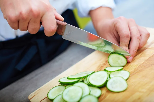 Hands slicing cucumber — Stock Photo, Image