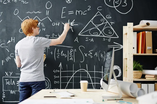 Estudiante escribiendo en pizarra — Foto de Stock