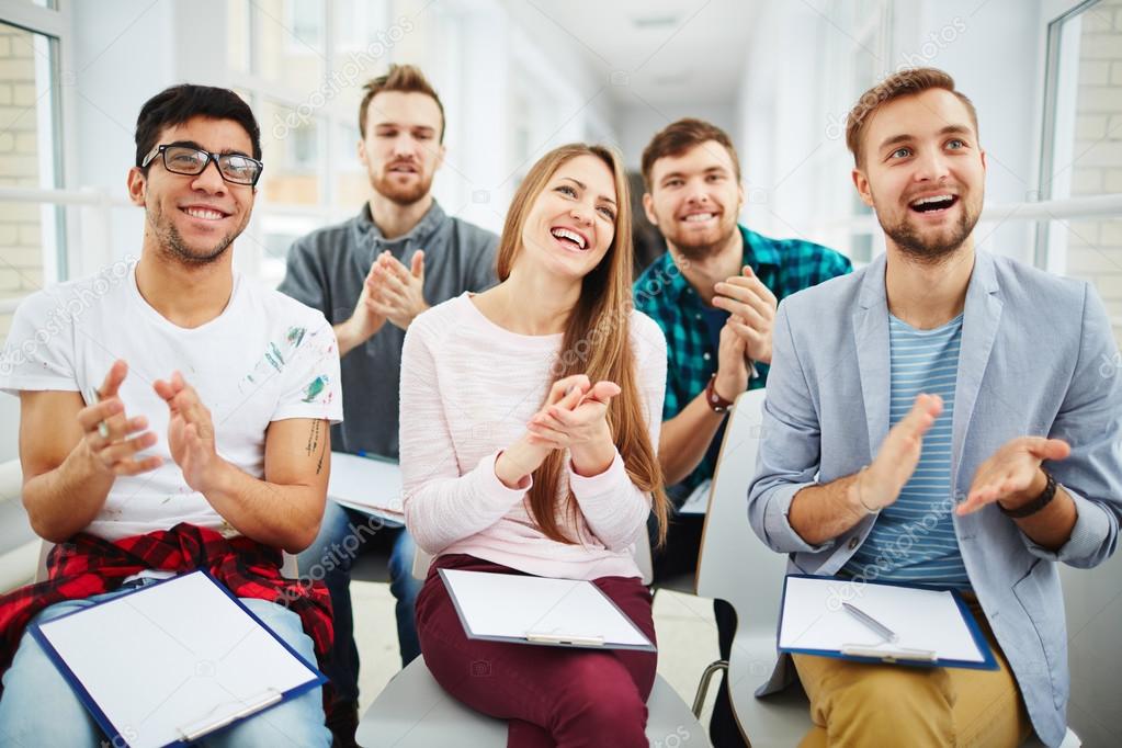 Happy young learners applauding to teacher after lecture