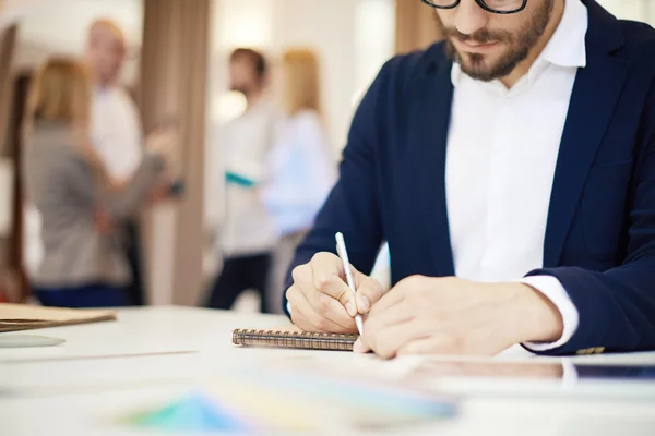 Businessman writing in notepad — Stock Photo, Image