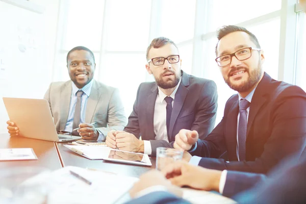 Hombres de negocios sonrientes durante la reunión —  Fotos de Stock