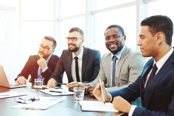 Toplantı sırasında gülümseyen iş adamları