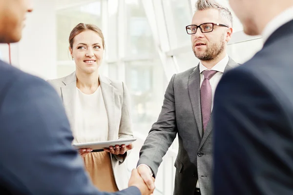 Colleagues looking at businessmen — Stock Photo, Image