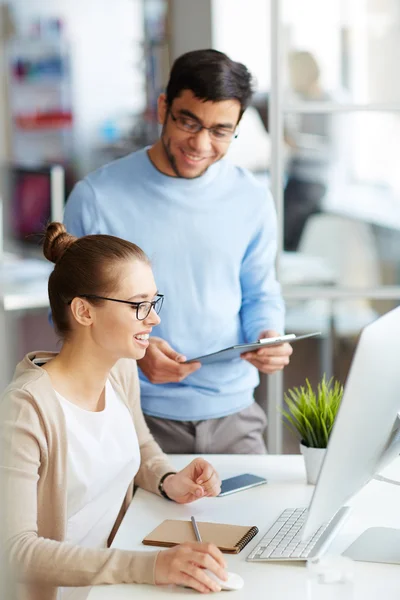 Geschäftsfrau und Kollegin blicken auf Monitor — Stockfoto