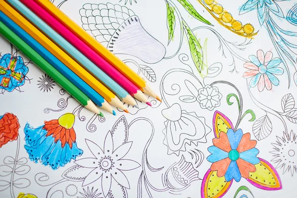 Pencils on coloring book — Stock Photo, Image