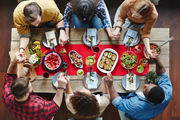 Amigos rezando antes do jantar — Fotografia de Stock