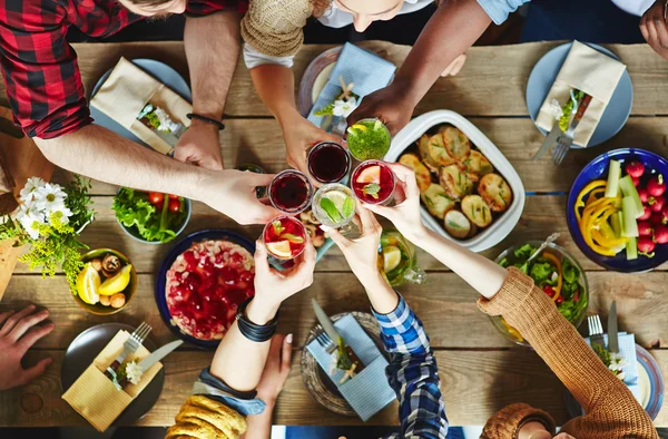 Freunde stoßen mit Cocktails an — Stockfoto