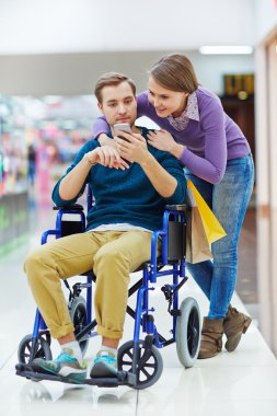 Adam fotoğrafları izlerken tekerlekli sandalyede