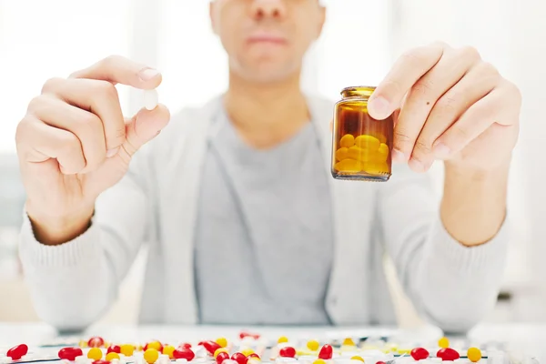 Homem segurando garrafa médica — Fotografia de Stock