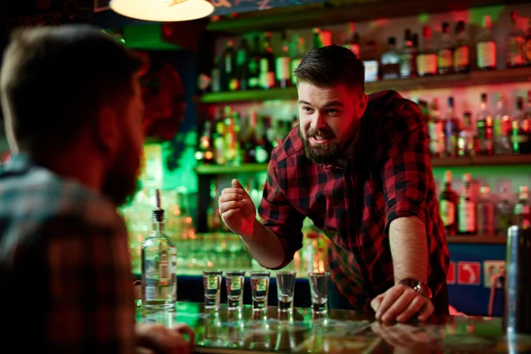 Barman e amigo conversando no pub — Fotografia de Stock