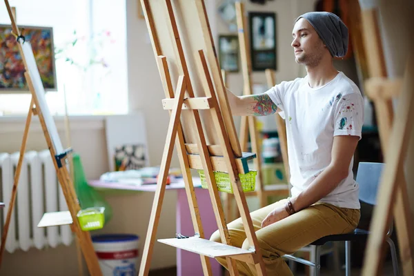 Student sitting by easel — Stock Photo, Image