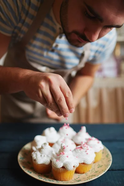 Homem que decora muffins — Fotografia de Stock