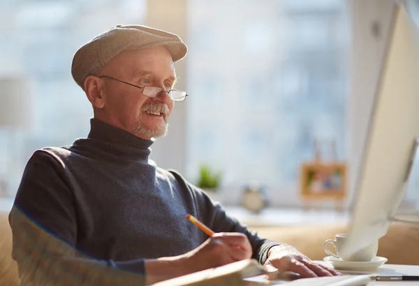 Reifer Mann macht sich Notizen — Stockfoto