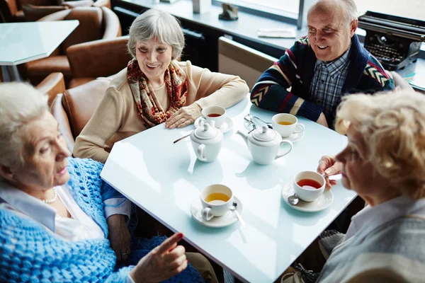 Пожилые люди, разговаривающие за чаем — стоковое фото