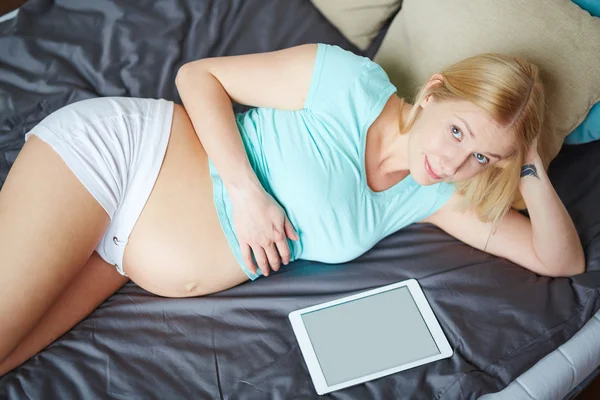 Donna incinta sdraiata sul letto — Foto Stock