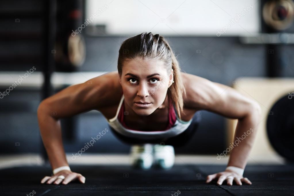 Woman doing push ups Stock Photo by ©pressmaster 107826368