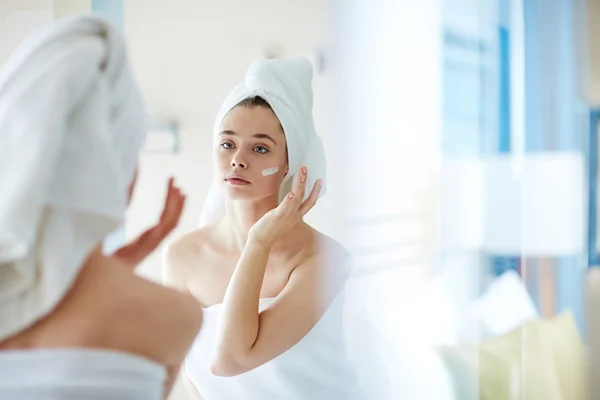 Mujer aplicando crema hidratante —  Fotos de Stock