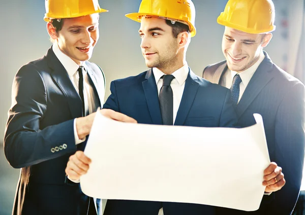 Engineers with construction plan — Stock Photo, Image