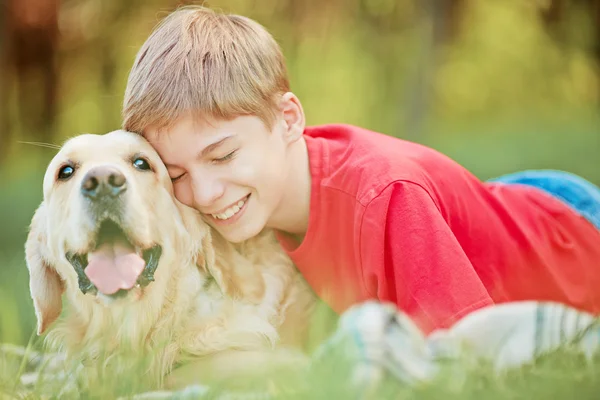 Menino abraçando cão — Fotografia de Stock