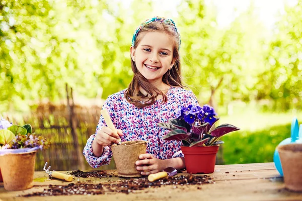 Girl planting violet — Stock Photo, Image