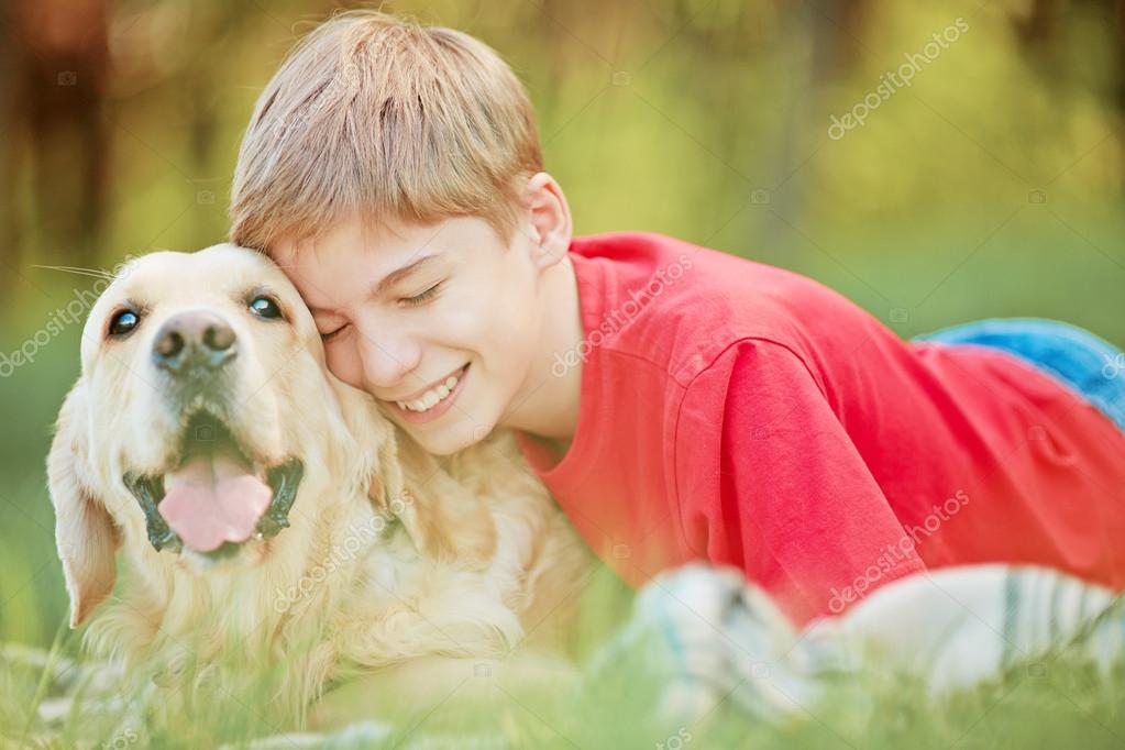 His friend kind. Мальчик обнимает собаку. Подросток обнимает собаку. Мальчик обнимает собаку на траве. Парень обнимается с лабрадорами на траве.