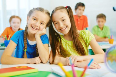 Gülümsüyor ile dostça kız öğrenciler 