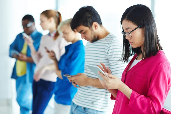 Estudiantes multiétnicos con gadgets — Foto de Stock